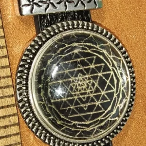 Sacred geometry pendant featuring etched Sri Yantra design under glass dome on black leather strap