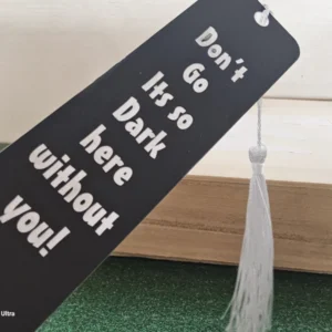 Black inspirational bookmark with white tassel – “Don’t go, it’s so dark here without you!”